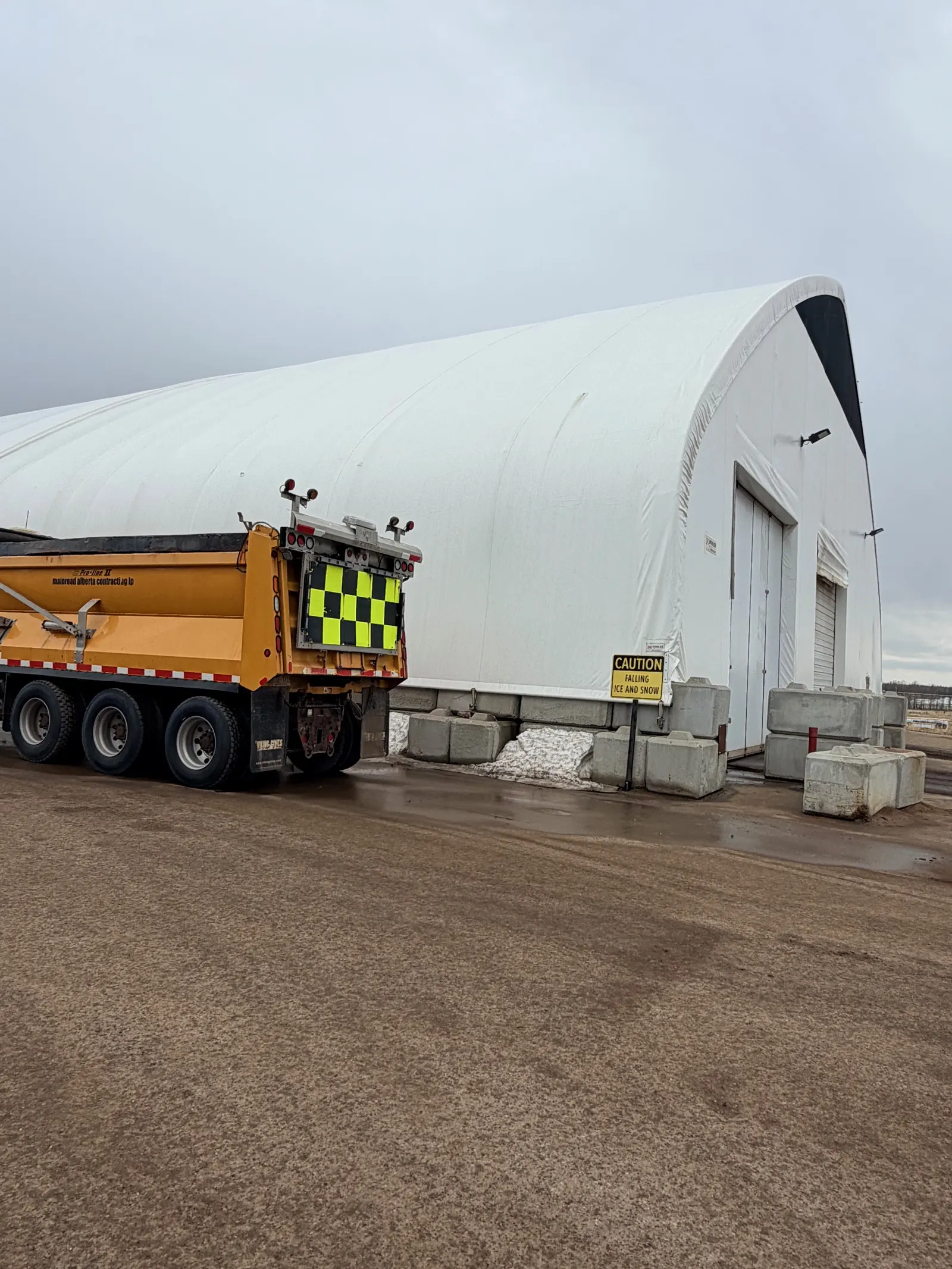 Municipal sand storage building with highway maintenance truck
