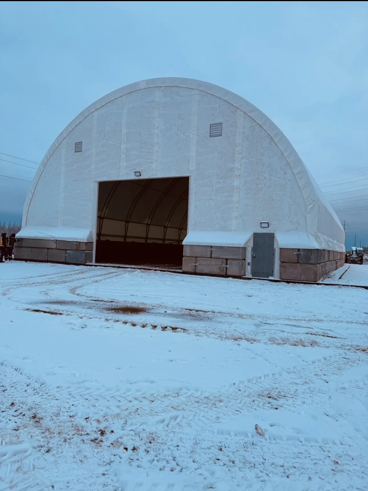 Clear-span fabric pipe storage building at an oilsands site in winter