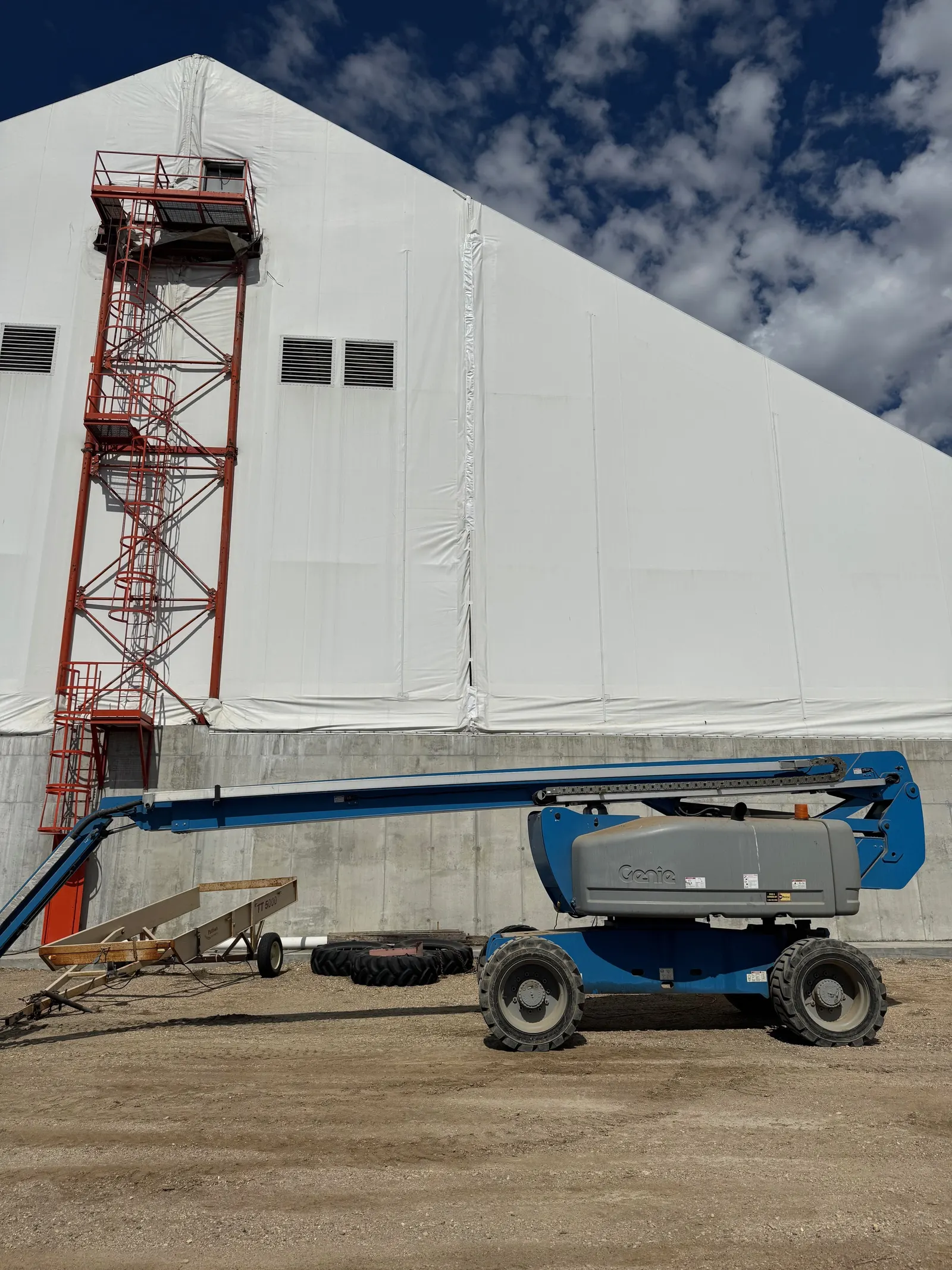 Boom lift crew on a fabric building wall during recover