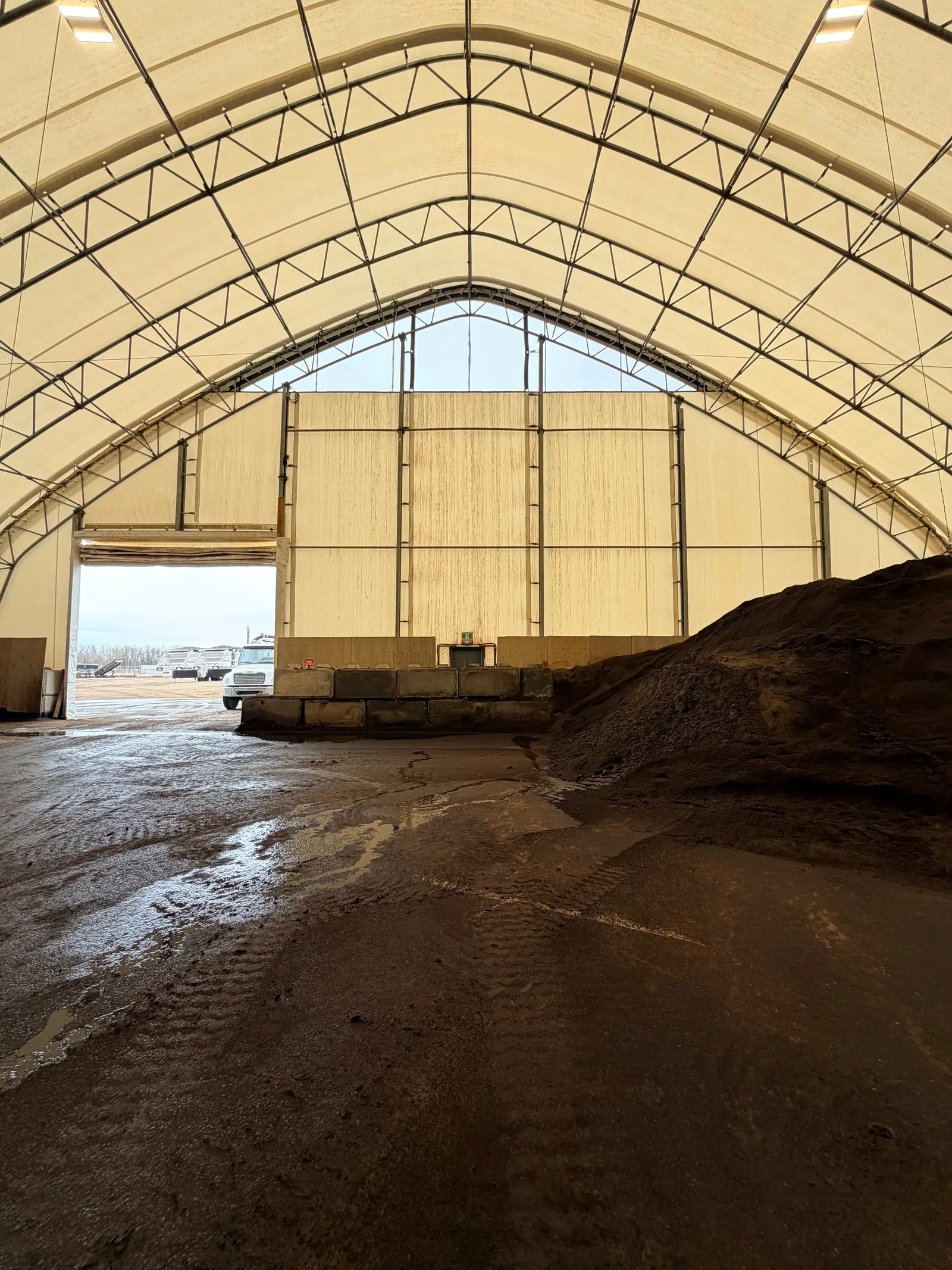 Sand stockpile inside a fabric storage building with lock block walls
